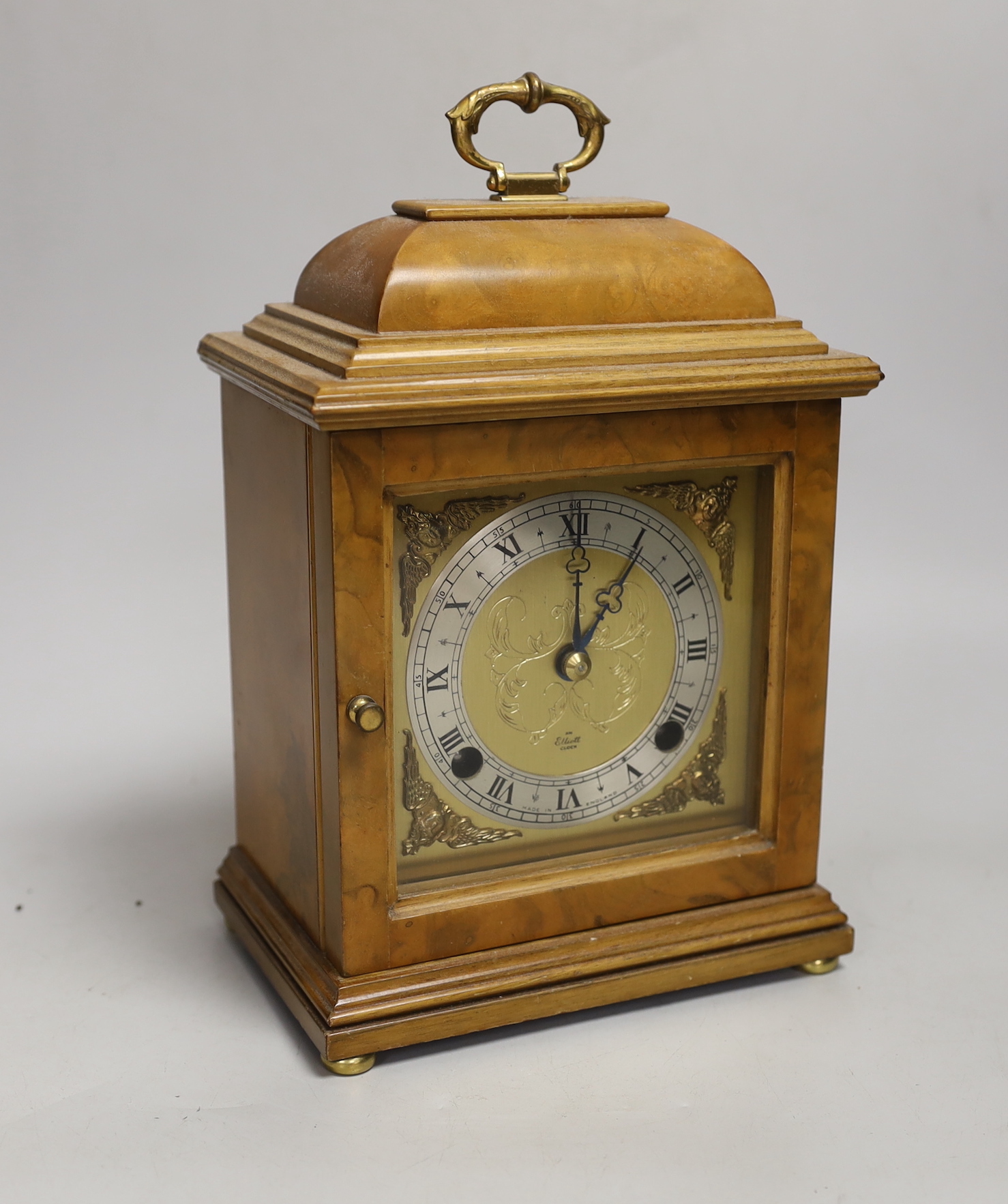 A figured walnut mantel clock by Elliott